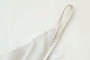 Gros plan détaillé de la dentelle et du satin sur le haut à bretelles crème élégant