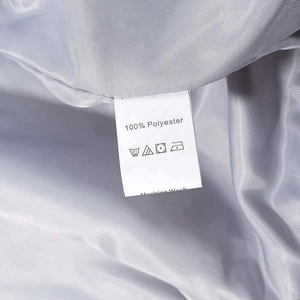 Gros plan sur l'étiquette d'entretien d'une veste en satin gris en 100% polyester