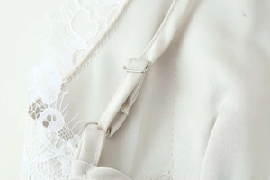 Détail de la bretelle réglable et de la dentelle florale sur une robe en satin