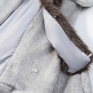 Détail de la texture pelucheuse de la veste grise et du col en fausse fourrure