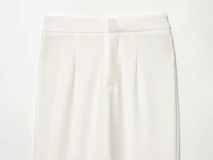 Vista dettagliata dei pantaloni bianchi a vita alta con cintura sartoriale e zip nascosta