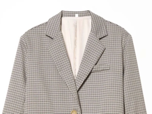 Close-up of houndstooth blazer showing notch lapel, chest pocket, and smooth lining