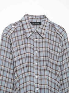 Detail of light blue plaid shirt dress featuring shoulder epaulettes and pointed collar