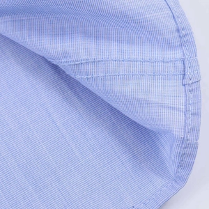 Close-up of light blue micro-plaid fabric with professional double-needle hem stitching