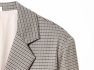 Macro shot of the houndstooth pattern and tailored lapel of this brown plaid blazer