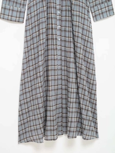 Detail of the light blue plaid shirt dress featuring white buttons and textured fabric