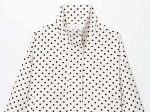 Detail of white puff sleeve jacket with black polka dots showing inner size S label
