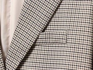 Close-up of houndstooth plaid blazer lapel with smooth lining and stitched pocket detail