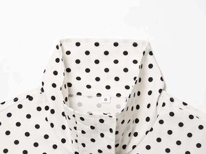 Close-up of the classic black polka dot shirt collar with size S label and stitching