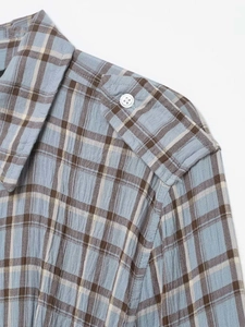 Detail view of light grey plaid shirt dress with button epaulettes and textured fabric