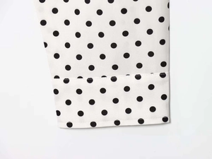 Macro detail of polka dot chiffon sleeve showing fine stitching and fabric texture