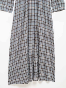 Detail view of the fine plaid fabric and buttoned cuff on this long-sleeved dress
