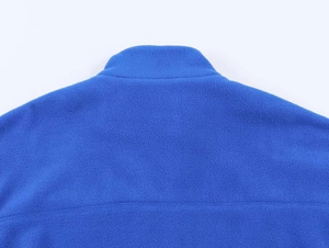 Detail of high-neck blue fleece jacket showing soft texture and shoulder stitching