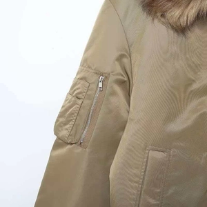 Detailed close-up of khaki aviator jacket sleeve pocket and brown faux fur collar