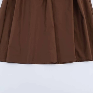 Detailed close-up of dark brown pleated midi skirt hem with premium woven texture