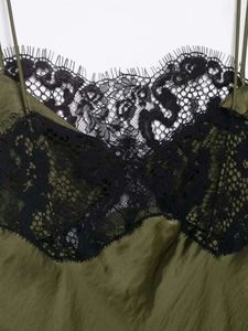 Detail of dark olive satin dress showing intricate black eyelash lace neckline trim
