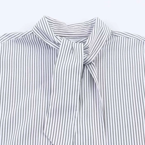 Detailed close-up of a black and white striped poplin shirt with a pussy-bow necktie