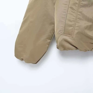 Detail of khaki faux fur bomber jacket showing ribbed cuff and pocket stitching