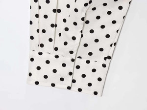 Detailed macro view of polka dot shirt cuff showing precise stitching and fabric texture