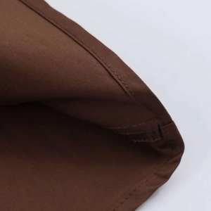 Detailed close-up of brown twill cotton fabric with flat and even pleated stitching detail