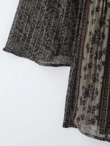 Detail aus transparentem Chiffon mit Vintage-Blumendruck und goldenen Streifen