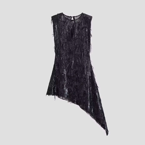 Détail d'une robe noire asymétrique sans manches avec sequins et texture à franges