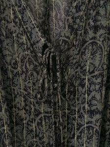 Detail von bedrucktem Kleidstoff mit Gold-Lurexstreifen und Paisley-Muster