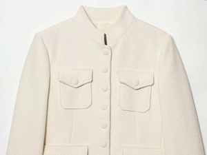 Detail of tweed jacket with stand collar, texture fabric, and flap pocket design