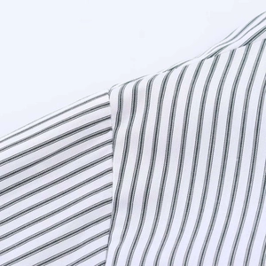 Detailed close-up showing the fine stitching and navy stripes on the poplin shirt shoulder