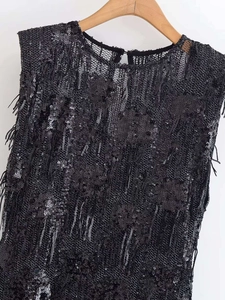 Détail d'une robe noire sans manches avec paillettes scintillantes et texture à franges