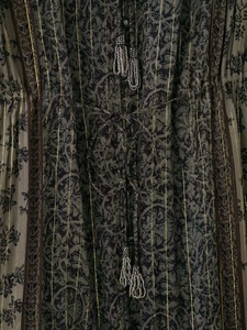 Detailansicht des Boho-Kleides mit goldenen Metallfäden und Perlenquasten am Kordelzug