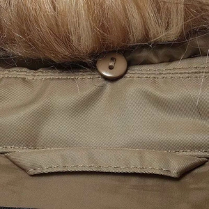Detailed macro shot of the khaki aviator jacket collar with brown faux fur trim and button