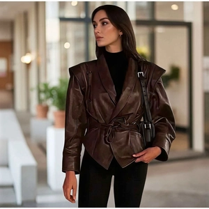 Dettaglio del cappotto in ecopelle marrone con spalle strutturate e cintura in vita annodata