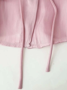 Detailed macro view of smooth pink satin shirt fabric with fine stitching and slim tie details