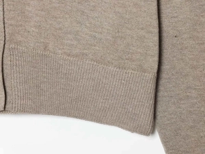 Detailed macro view of khaki knit cardigan showing premium ribbed cuffs and fine stitching