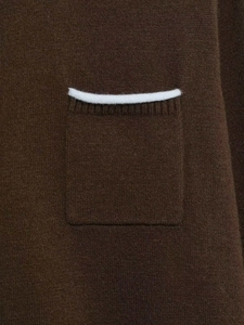Detailed macro view of a dark brown knit cardigan featuring a square pocket with white piping