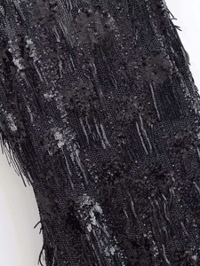 Détails du tissu à paillettes noires avec de denses franges sur cette robe élégante