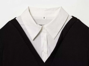 Détail d'une chemise blanche boutonnée sous un pull en maille côtelée noire à col en V