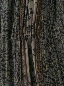 Makroaufnahme von Stoff mit Metalldrahtdruck, Faltenstruktur und Blumenmustern