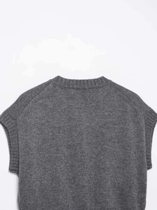 Detail of the grey knit vest showing a ribbed crew neck and fine shoulder stitching texture