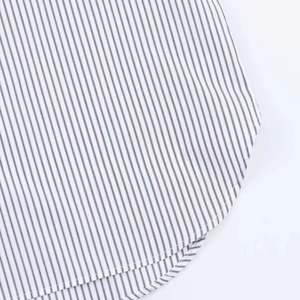 Macro view of a striped poplin shirt featuring a curved hem and precise stitching detail