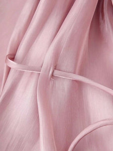 Detailed macro view of the smooth pink satin fabric and stitched drawstring connection