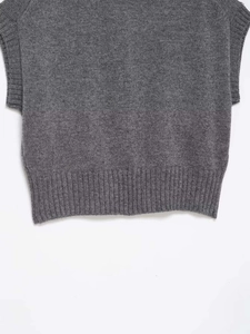 Detailed macro view of gray knitted vest featuring ribbed hem and fine fabric texture