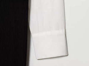 Détail montrant le contraste entre la maille côtelée noire et le tissu de la manche en popeline