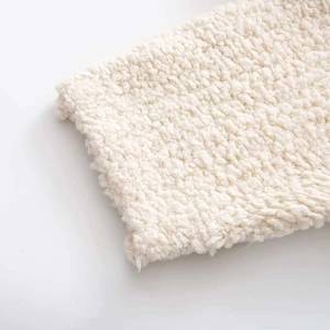 Close-up of premium bouclé knit fabric texture in creamy white for women's autumn coat