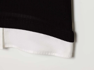 Détail de l'ourlet en popeline cousu sur le tissu en maille côtelée d'une robe