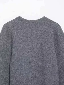Detail of gray knitted cardigan neckline showing tweed texture and round collar design
