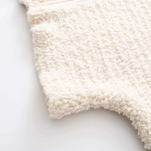 Detailed close-up showing the soft texture of white sherpa knit fabric for women's outerwear
