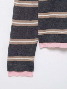 Detail of grey and beige striped knit sweater featuring pink ribbed cuffs and hem texture
