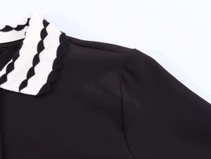 Detail view of contrast polo collar with wavy pattern and premium knit stitching
